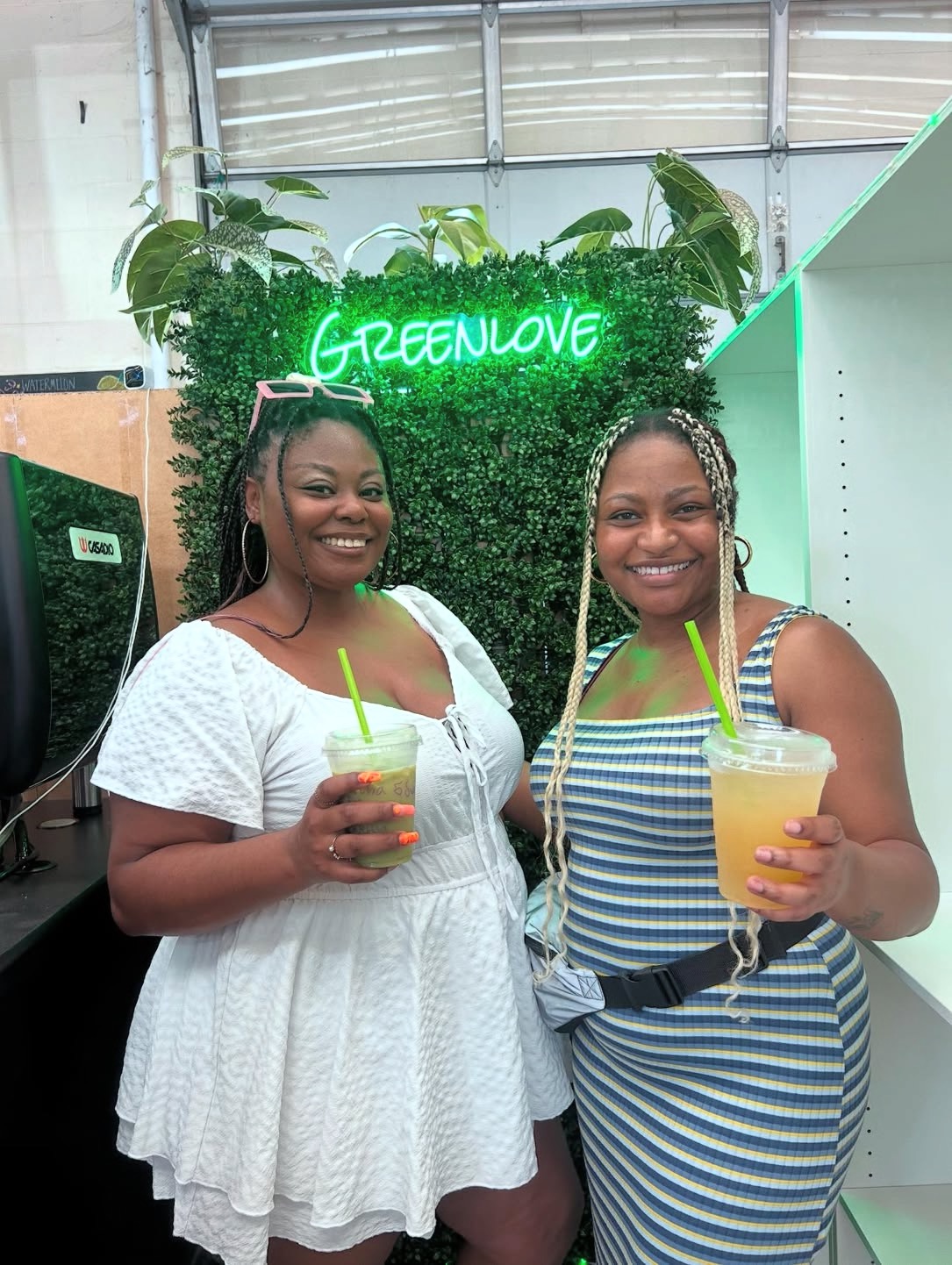 Two friends holding Greenlove drinks