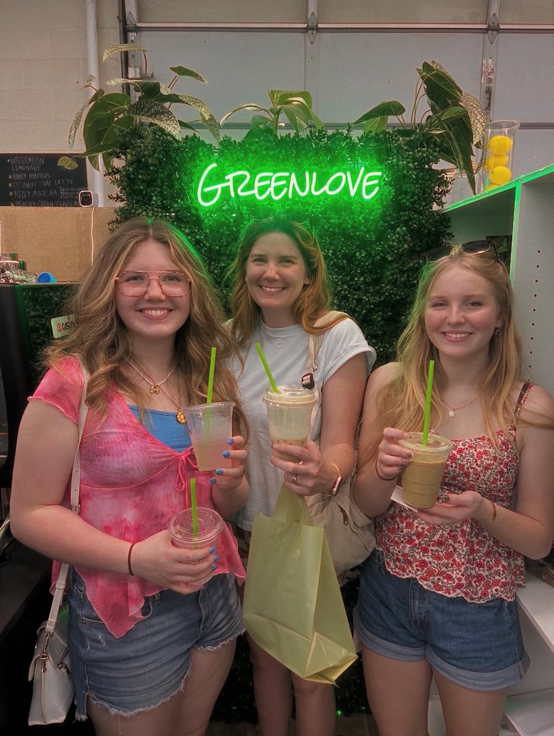 Guests with drinks under the Greenlove sign